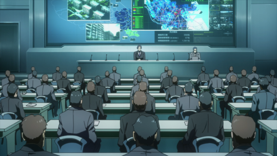 Members of the CCG, mostly dudes in suits, sitting in rows in a brightly lit room.