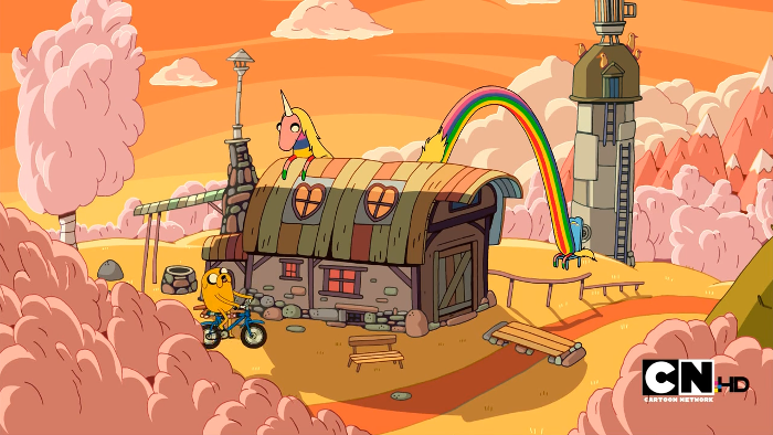 Jake cycles up to Lady Rainicorn, who is balanced between a tiny chair in the background and a barn in the foreground.
