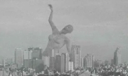 A giant grey woman with a long tongue looming over Tokyo.